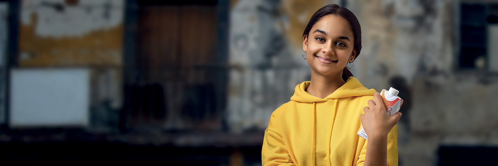 Tetra Pak girl in yellow hoodie with carton